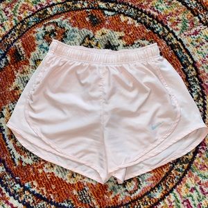 Baby pink Nike running shorts.